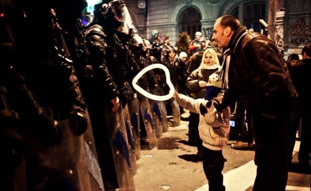 Romanian kid giving heart balloon to police