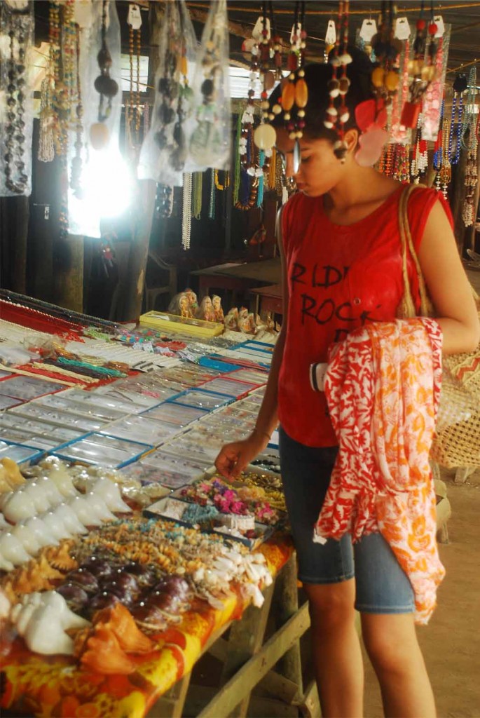 A girl walks around searching curios at Radhanagar beach market